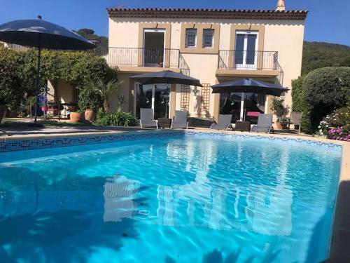 une grande piscine bleue devant une maison dans l'établissement Très belle maison piscine chauffé 210M2 climatisé, à Sainte-Maxime