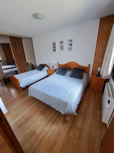 1 Schlafzimmer mit 2 Betten und Holzboden in der Unterkunft Apartamento Pas de la Casa - 6 pax in Pas de la Casa