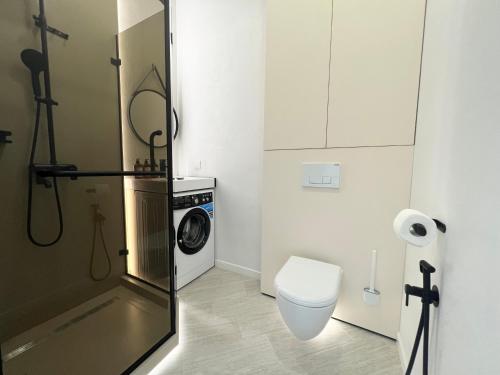 a bathroom with a washing machine and a toilet at LUX Апартаменты SMART #7 in Pavlodar