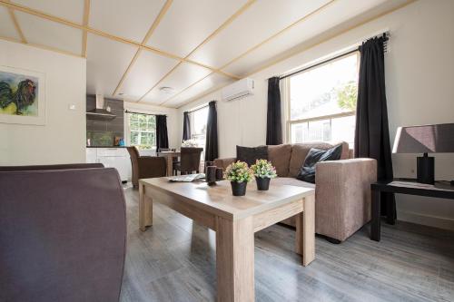 a living room with a table and a couch at 16, Geniet van de rust, natuur & gratis parkeren! in Oisterwijk