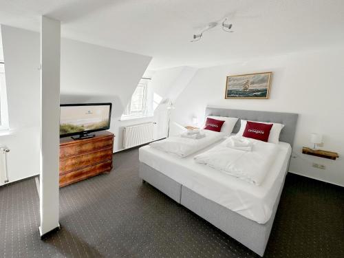 a bedroom with a large bed and a flat screen tv at Groegers Ferienzimmer in Hohwacht