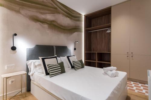 1 dormitorio con 1 cama blanca grande con almohadas en Estudio vanguardista- 1B- Chamberí, en Madrid