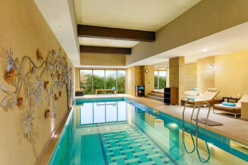 a swimming pool in a hotel room with a living room at Karma Chalets in Gurgaon