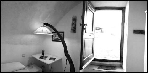 Cette chambre dispose d'une lampe, d'un lavabo et d'une fenêtre. dans l'établissement Le Pagliare Del Gran Sasso, à Assergi