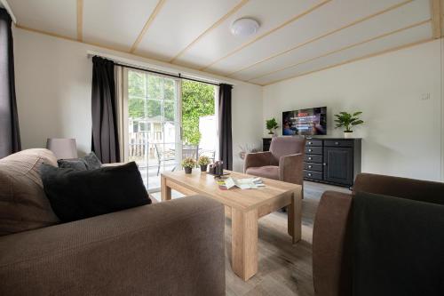 a living room with a couch and a table at 16, Geniet van de rust, natuur & gratis parkeren! in Oisterwijk