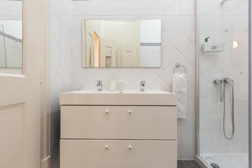 bagno bianco con lavandino e specchio di 4BR Lisbon Apartment - Central Location a Lisbona