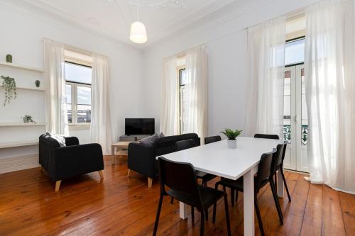 una sala da pranzo con tavolo e sedie bianchi di 4BR Lisbon Apartment - Central Location a Lisbona