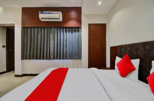 ein Schlafzimmer mit einem großen weißen Bett mit roten Kissen in der Unterkunft Hotel Maharaja in Udaipur