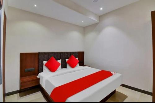 Hotel Maharaja في أودايبور: غرفة نوم بسرير كبير ومخدات حمراء