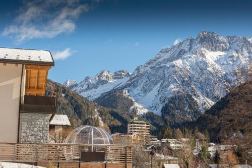 a building with a mountain in the background at B&B Alpen Suite Ponte di Legno in Ponte di Legno