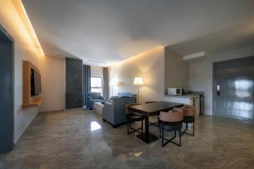 ein Wohnzimmer mit Tisch und Stühlen und einer Couch in der Unterkunft فندق بيرلي ابها in Abha