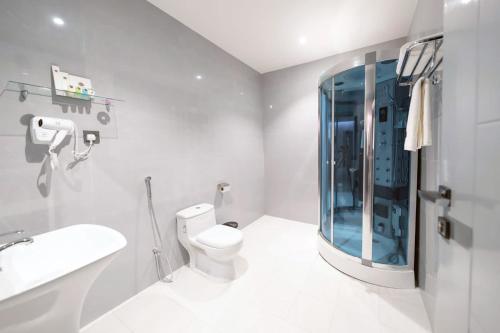 a bathroom with a toilet and a glass shower at فندق بيرلي ابها in Abha