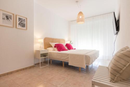 a bedroom with a bed with pink pillows on it at Beach Paradise Flat in Denia Centre w/ Large Pool in Denia