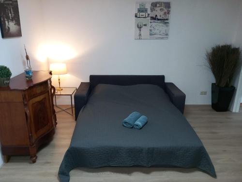 łóżko z 2 niebieskimi kapciami w pokoju w obiekcie Dorpszicht Yerseke centrum w mieście Yerseke