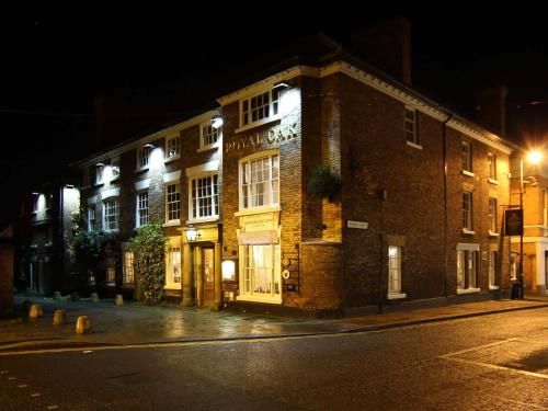 a large brick building on a street at night at The Royal Oak Hotel, Welshpool - The Coaching Inn Group in Welshpool