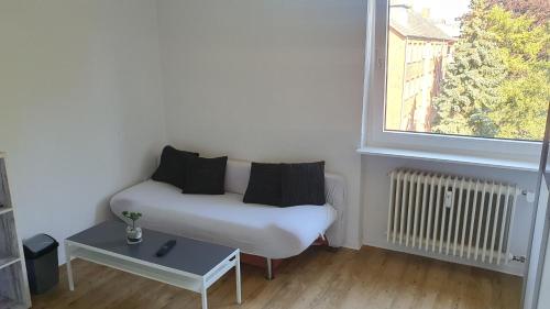 una pequeña sala de estar con sofá y ventana en Privatzimmer in St. Jürgen, gute Anbindung Zentral en Lübeck