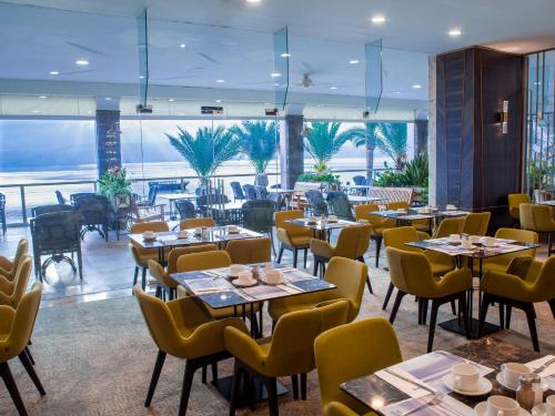 a restaurant with tables and chairs with a view of the ocean at Caesar Premier Tiberias Hotel in Tiberias
