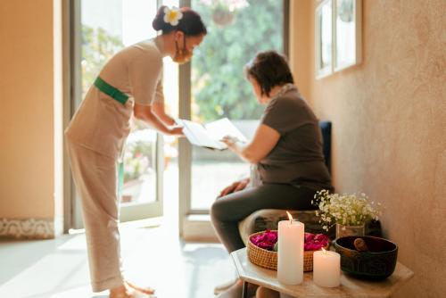 two women standing in a room looking at a paper at Karma Chalets in Gurgaon