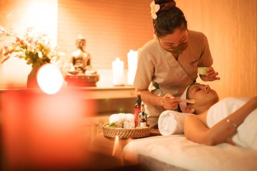 a woman brushing a womans teeth in a hotel room at Karma Chalets in Gurgaon