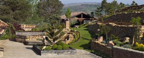 a garden with a stone wall and a house at Vinařský penzion André in Velké Pavlovice