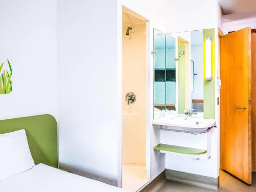 La salle de bains est pourvue d'un lavabo et d'un miroir. dans l'établissement ibis budget Glasgow, à Glasgow