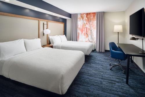 a hotel room with two beds and a desk at Fairfield Inn & Suites Auburn Opelika in Opelika
