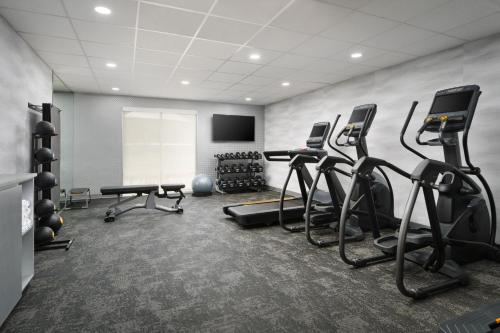 a gym with several treadmills and exercise bikes at Fairfield Inn & Suites Auburn Opelika in Opelika