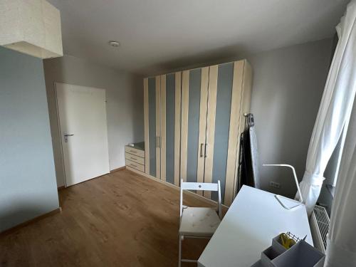 Zimmer mit einem Schreibtisch, einem Schrank und einem Tisch in der Unterkunft Minimalharmony Apartment in Hannover