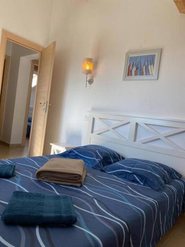 une chambre avec un lit avec des draps et des oreillers bleus dans l'établissement Saint-Florent Appartement duplex, à Oletta