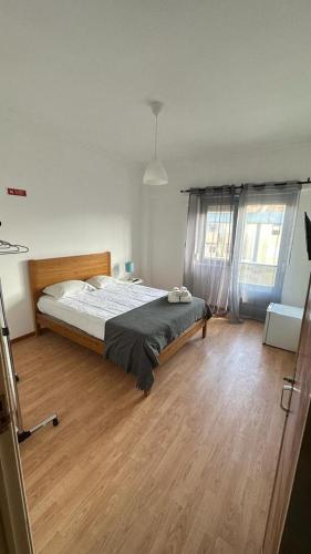 sypialnia z łóżkiem i drewnianą podłogą w obiekcie 7 Requinte Guest House w Lizbonie