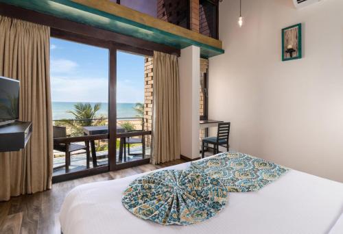 - une chambre avec un lit et une vue sur l'océan dans l'établissement Inidi Leisure Luxury Villas, à Wadduwa