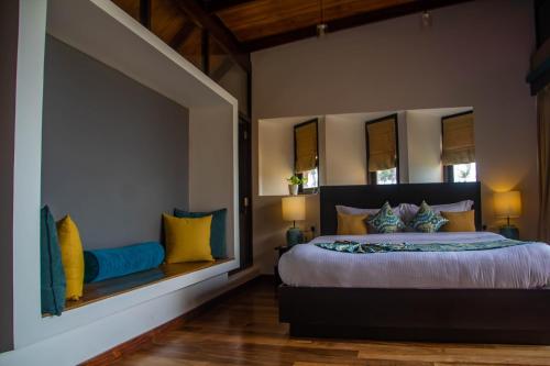 a bedroom with a large bed with yellow and blue pillows at Inidi Leisure Luxury Villas in Wadduwa