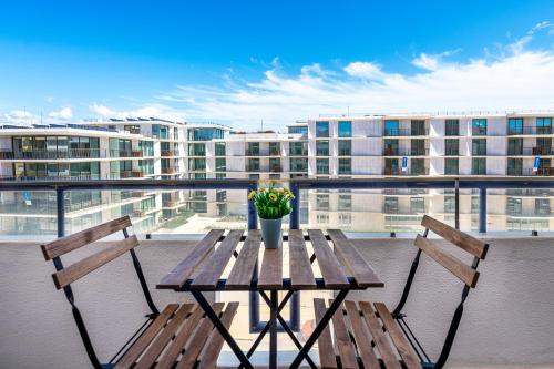 een houten tafel en 2 stoelen op een balkon bij Beachfront apartment in Armação in Armação de Pêra