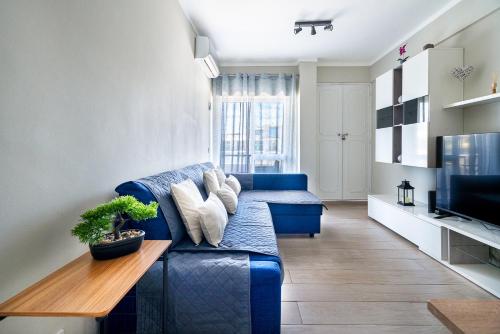 a living room with a blue couch and a table at Beachfront apartment in Armação in Armação de Pêra