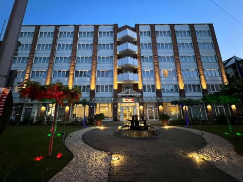 a large building with a fountain in front of it at Best Western Plus Delta Park Hotel in Mannheim
