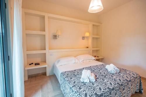 a bedroom with a bed with two stuffed animals on it at Fattoria delle Ripalte in Capoliveri