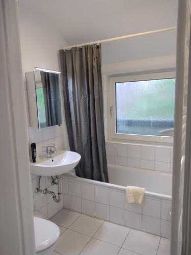 ein Badezimmer mit einem Waschbecken, einer Badewanne und einem WC in der Unterkunft Excellent Hotel Hamburg in Hamburg
