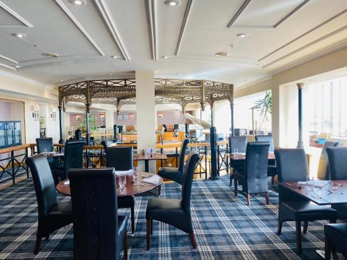 ein Restaurant mit Tischen und Stühlen in einem Zimmer in der Unterkunft Grand Hotel Sunderland in Sunderland