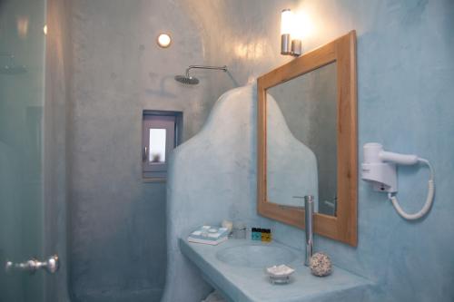 a bathroom with a sink and a mirror at Fanari Vista Suites in Fira