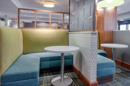 a waiting room with two tables and blue seats at Hampton Inn Baltimore/White Marsh in White Marsh
