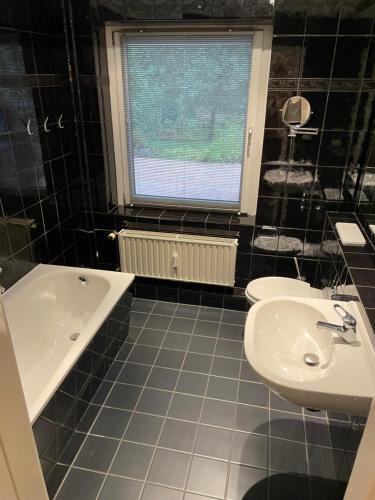 Wohnung 4 Zi Küche 2 Bad 4-12 P Hamburg mykojede في Braak: حمام مع حوض وحوض استحمام ومرحاض