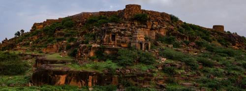 a large rocky mountain with vegetation on it at Wada1 in Aihole