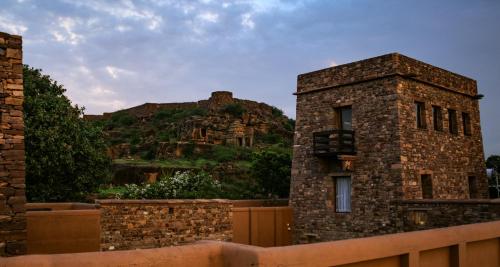 a stone building with a mountain in the background at Wada1 in Aihole