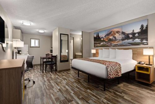 a hotel room with a bed and a desk at Days Inn by Wyndham Lakewood South Tacoma in Lakewood