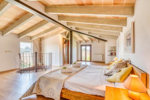 Cama grande en habitación con suelo de madera y techo de madera. en Ideal Property Mallorca - Can Ribas, en Can Picafort