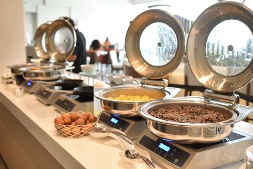 a buffet with bowls of food on a counter at Hilton Garden Inn Santa Ana, San Jose in San José