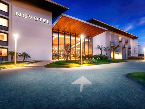 Novotel Itu Terras de São José Golf & Resort في إتو: سهم مشيرا إلى مبنى نويتر في الليل