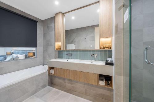 a bathroom with a tub and a sink and a shower at Ingot Hotel Perth, Ascend Hotel Collection in Perth