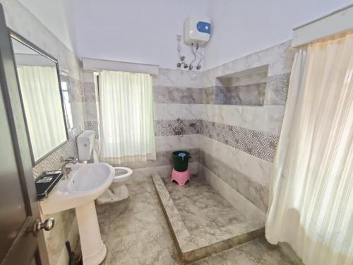 a bathroom with a sink and a toilet and a mirror at The Fateh Hotel by Le Pension Stays in Udaipur
