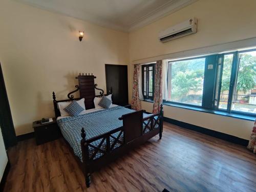 um quarto com uma cama e uma grande janela em The Fateh Hotel by Le Pension Stays em Udaipur